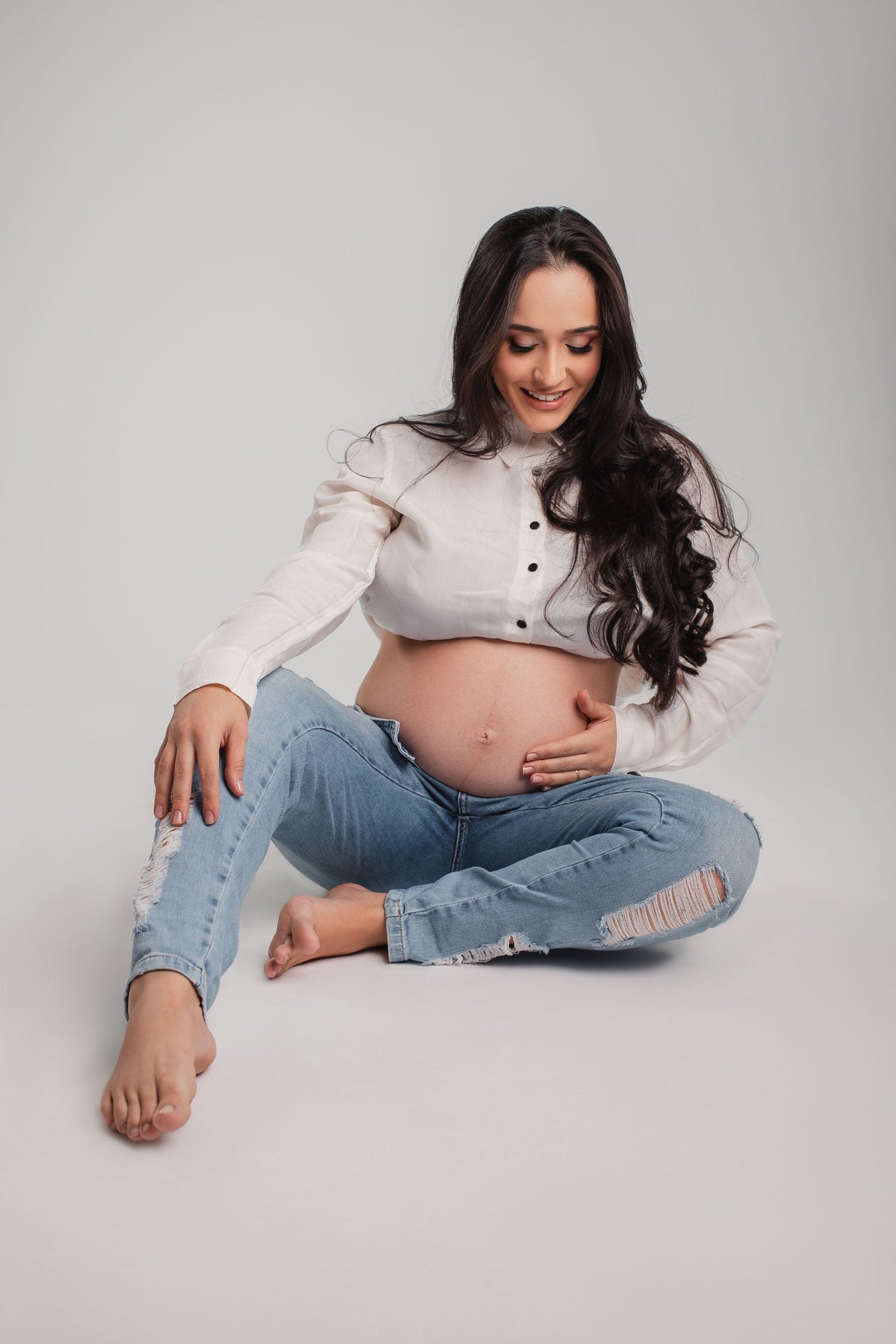 Zwangere vrouw in jeans en lichte blouse